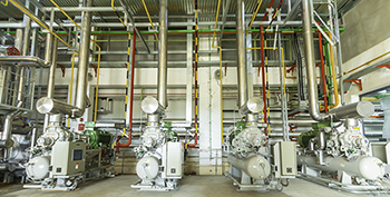 Industrial refrigeration equipment and piping inside a mechanical facility.